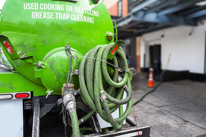 heavy-duty vacuum truck pumping out a grease trap in Astor